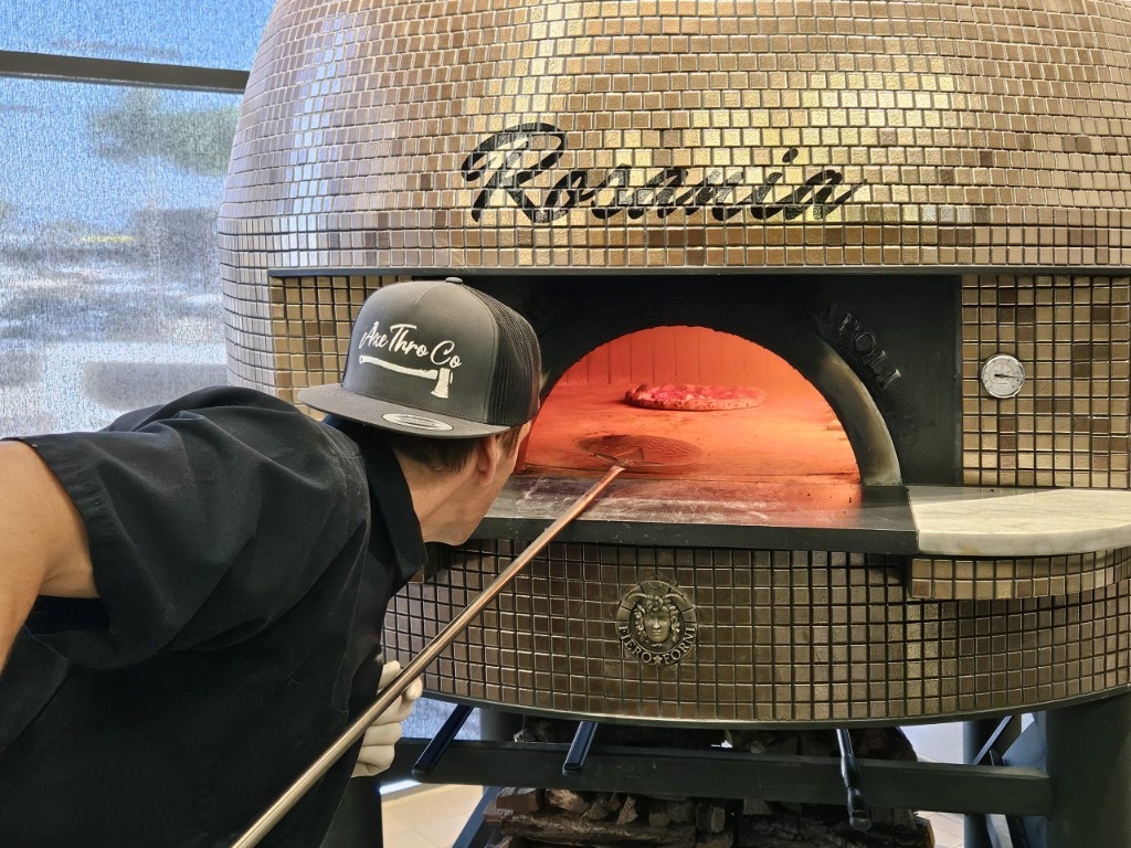 Acunto wood-fired pizza oven glowing inside Axe Thro Co